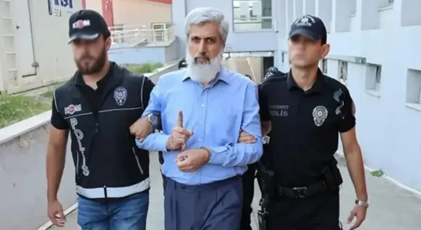 Alparslan Kuytul, kendinden habersiz hareket eden örgüt üyesinin sırtında sopa kırmış